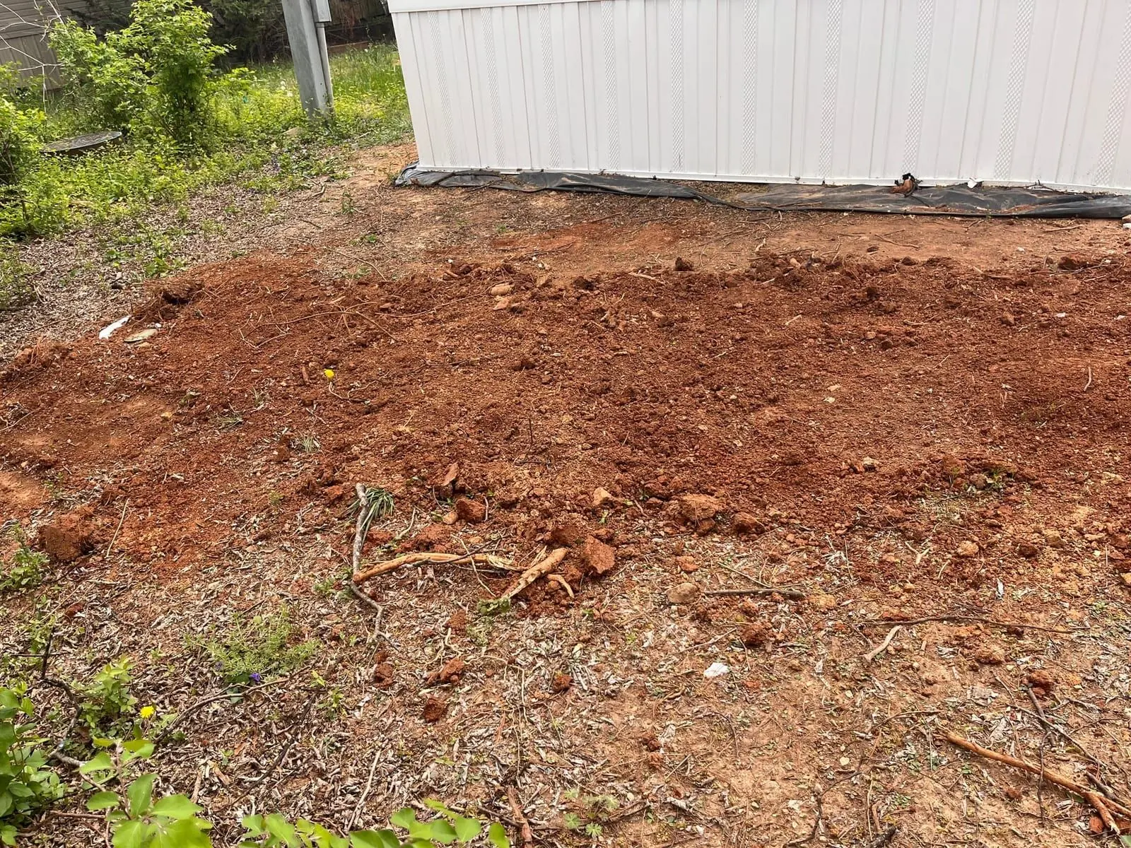 Trench dug alongside a home foundation for buried drain pipe