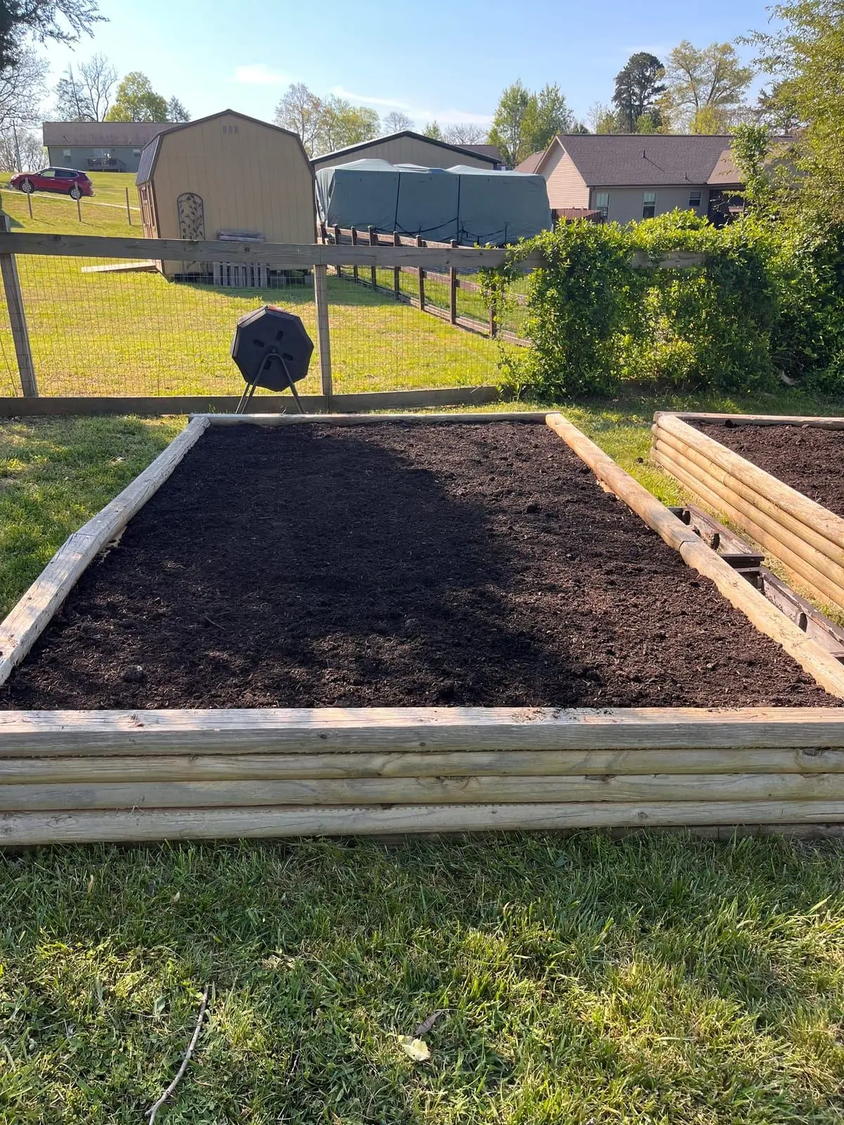 Timber-framed raised garden bed filled with rich compost