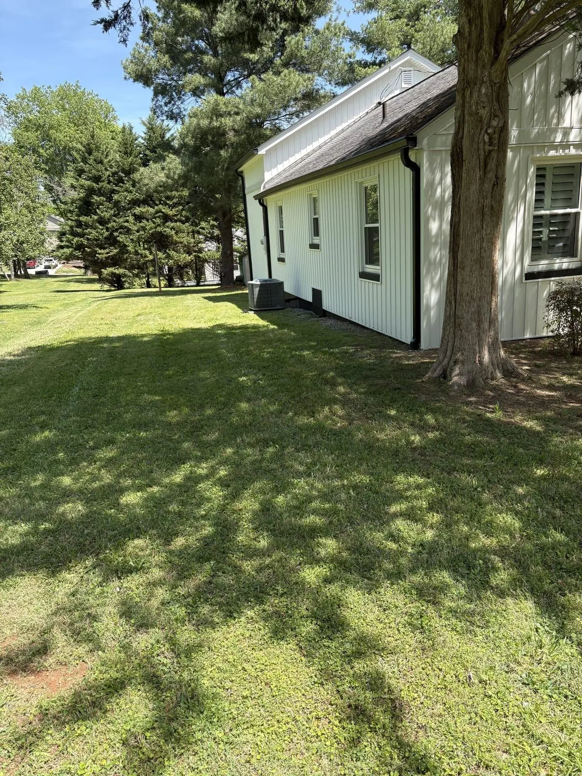 White farmhouse lawn fresh-mowed with a zero-turn