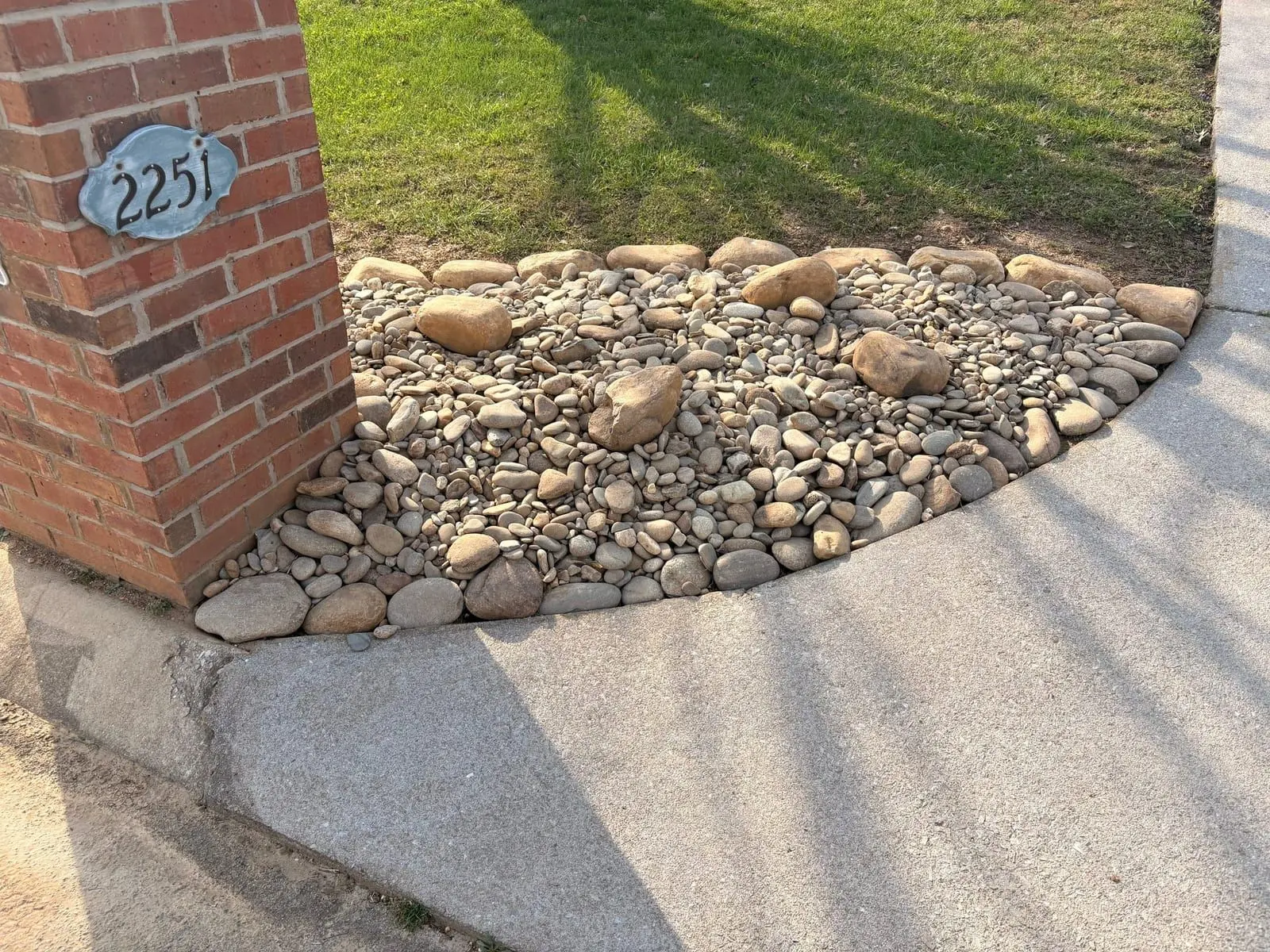River-rock bed channeling run-off along a home foundation