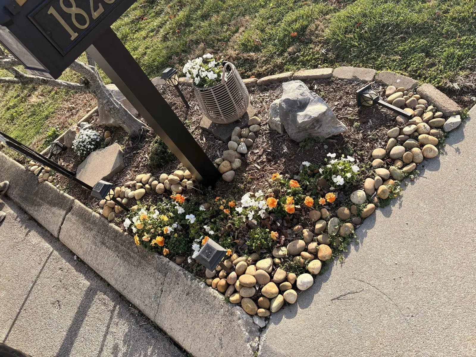 Mailbox bed with stone border and fresh plantings