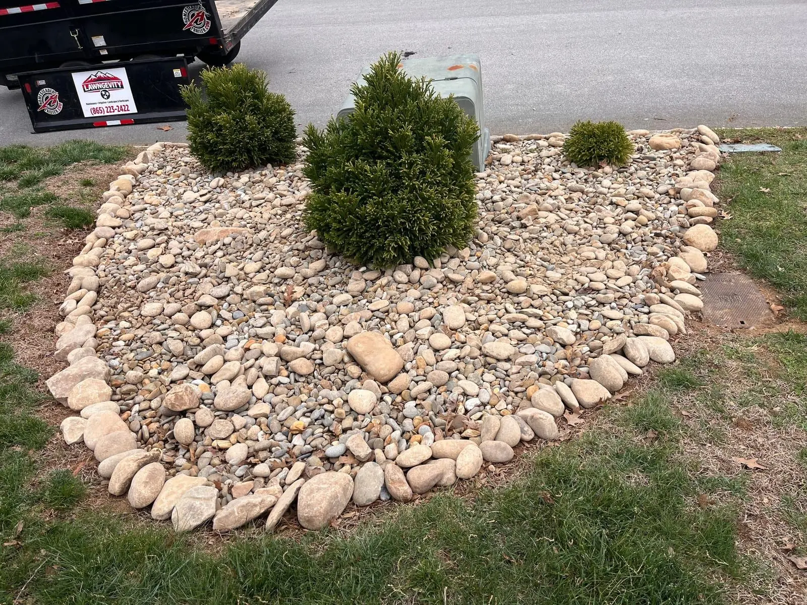 River-rock bed with shrubs and a cobble border